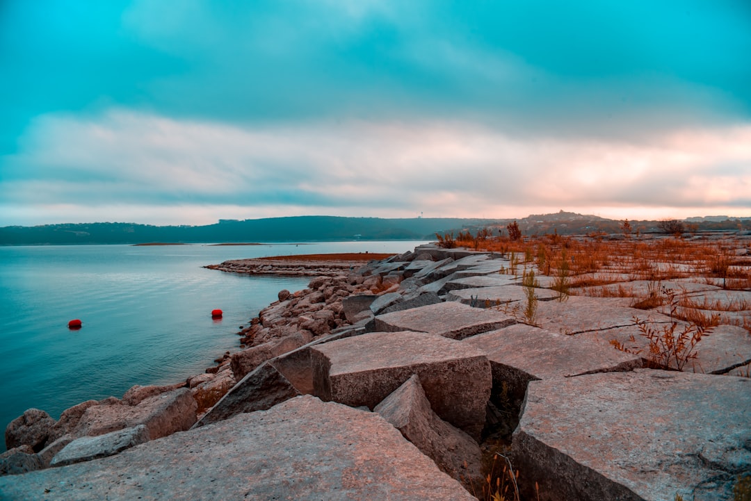 brown concrete dock near body of water during daytime