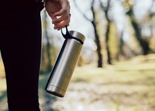 person holding stainless steel vacuum flask