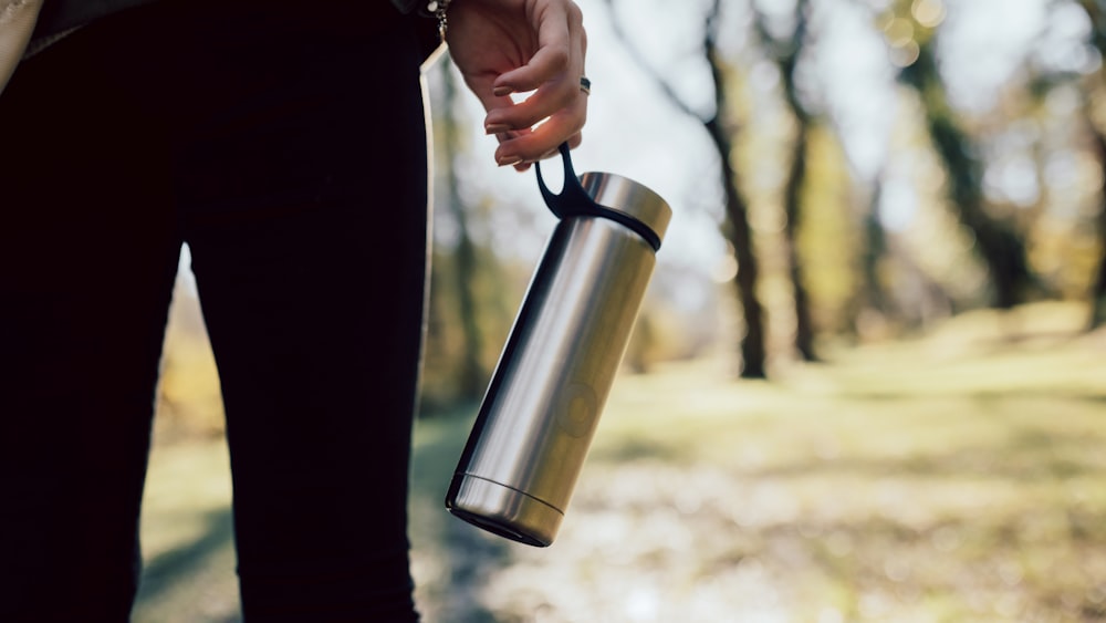 Person mit Edelstahl-Isolierflasche