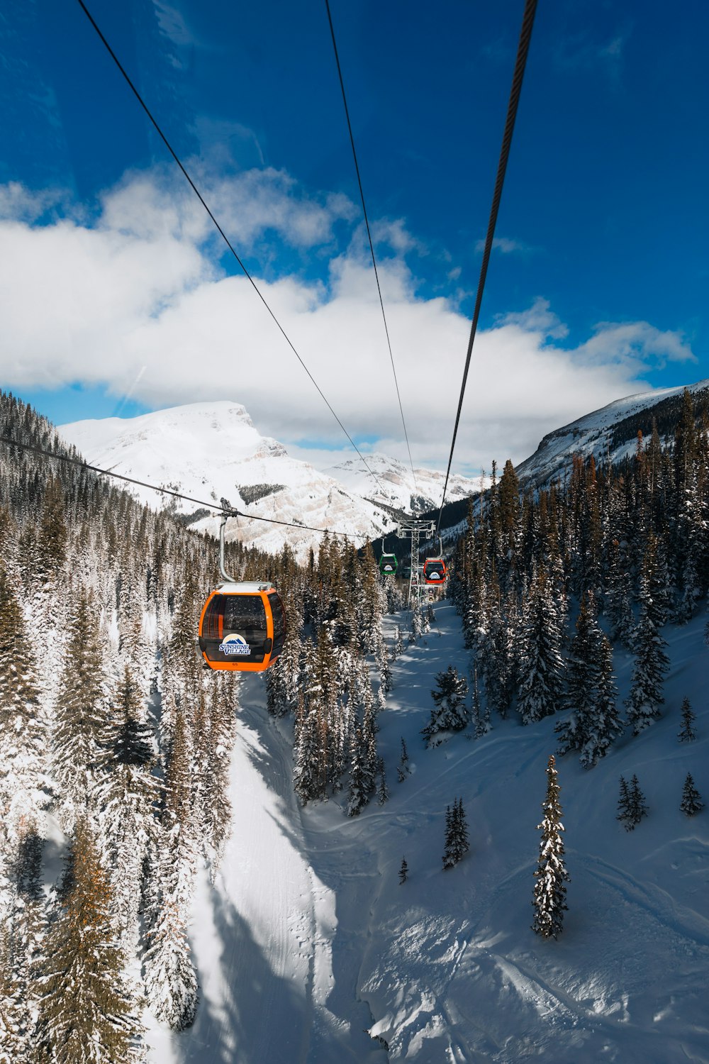 yellow and black cable car over snow covered mountain