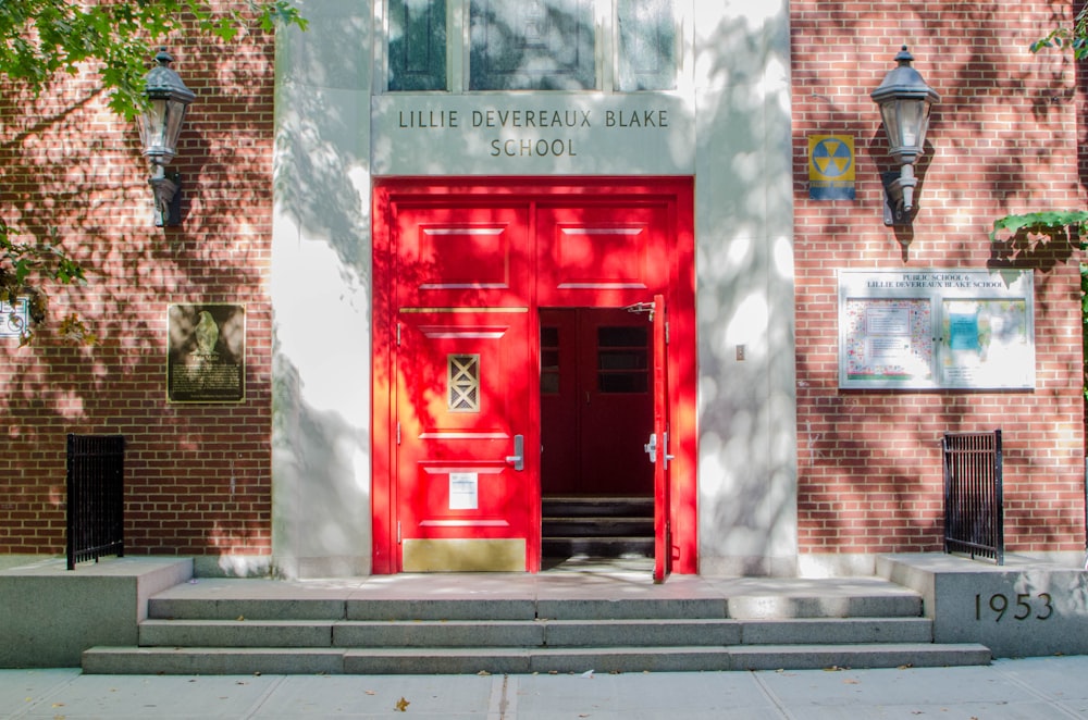 red telephone booth beside brown brick wall