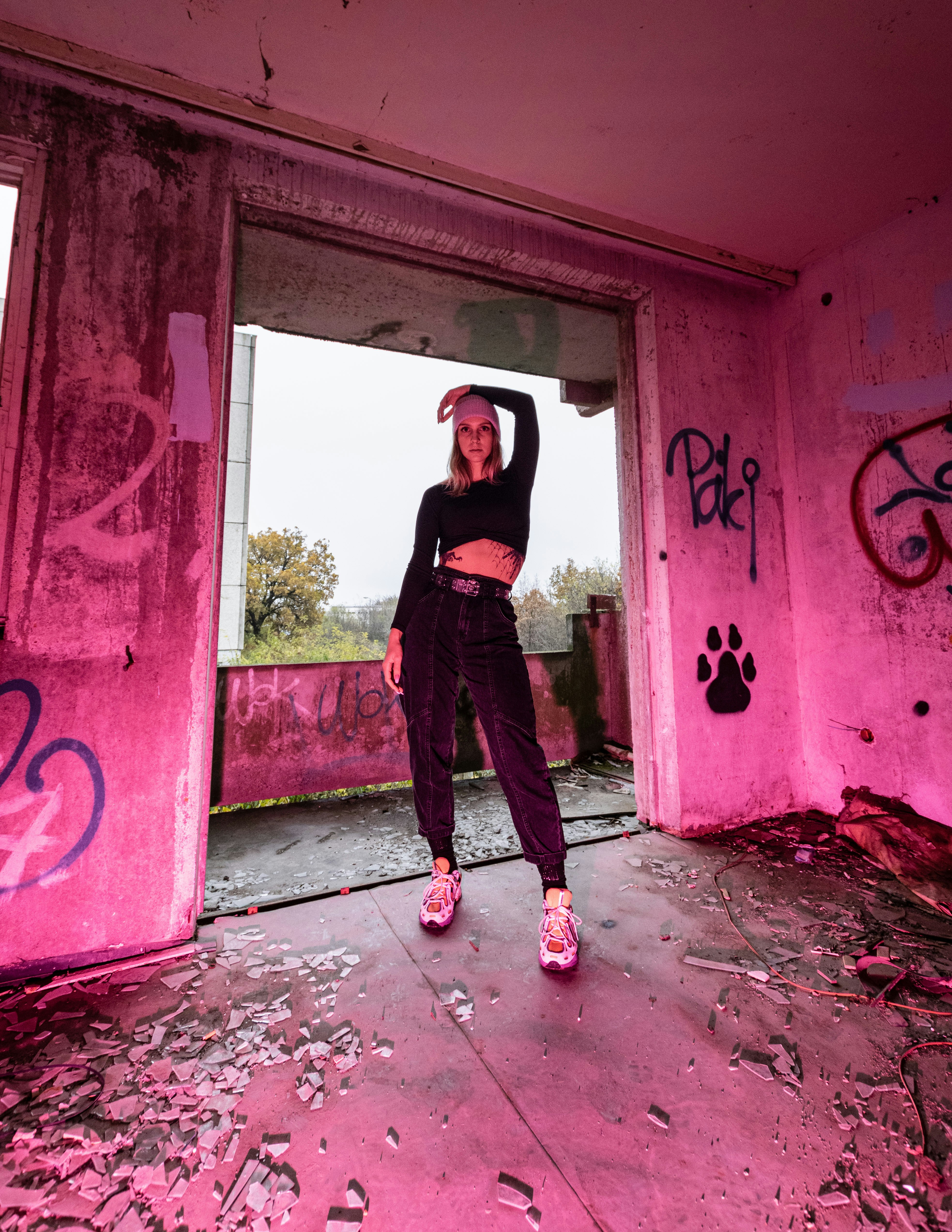 homme en t-shirt noir et pantalon noir debout sur le mur floral rouge et blanc