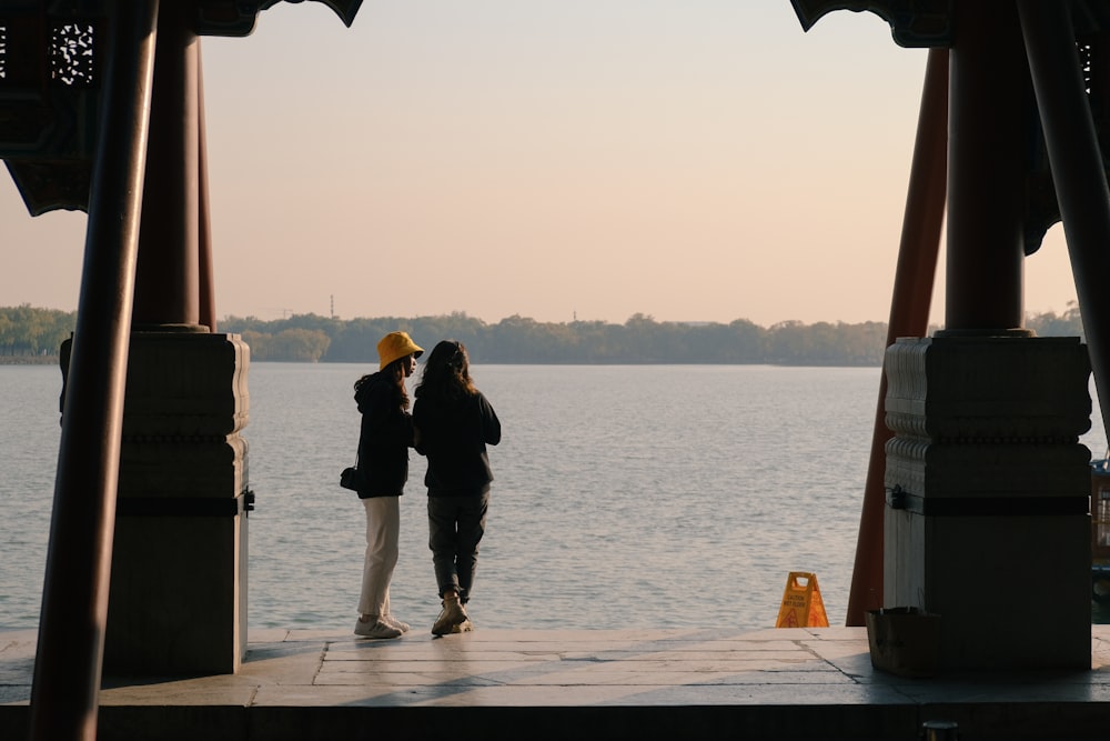 man and woman standing on dock during daytime