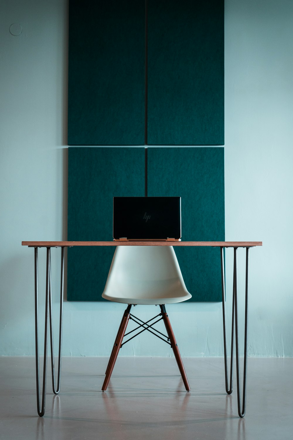 brown wooden seat beside black and white wall