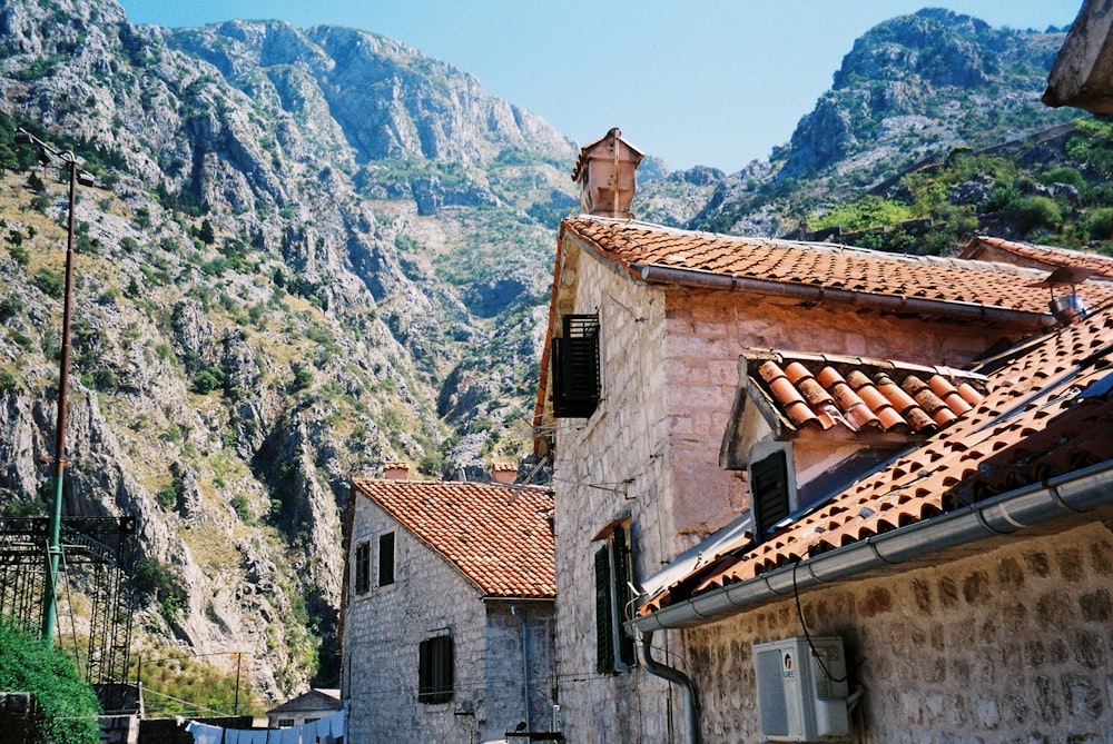 brown and white concrete house near mountain during daytime