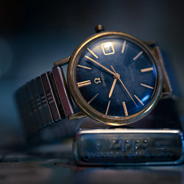 A gold and silver analog wristwatch photographed close up with a blurred background
