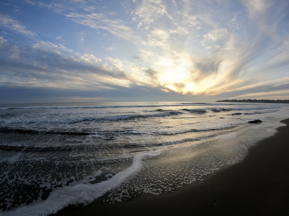 ocean waves crashing on shore during daytime