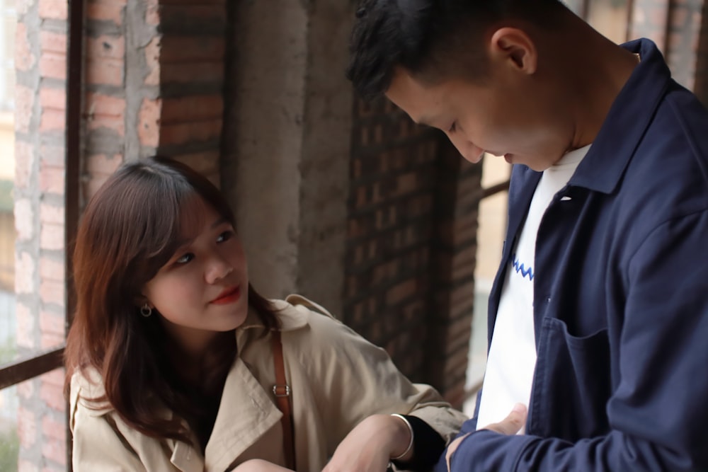 man in brown button up shirt beside woman in brown coat