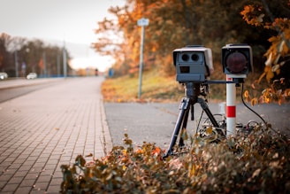 black and gray camera on tripod on road during daytime