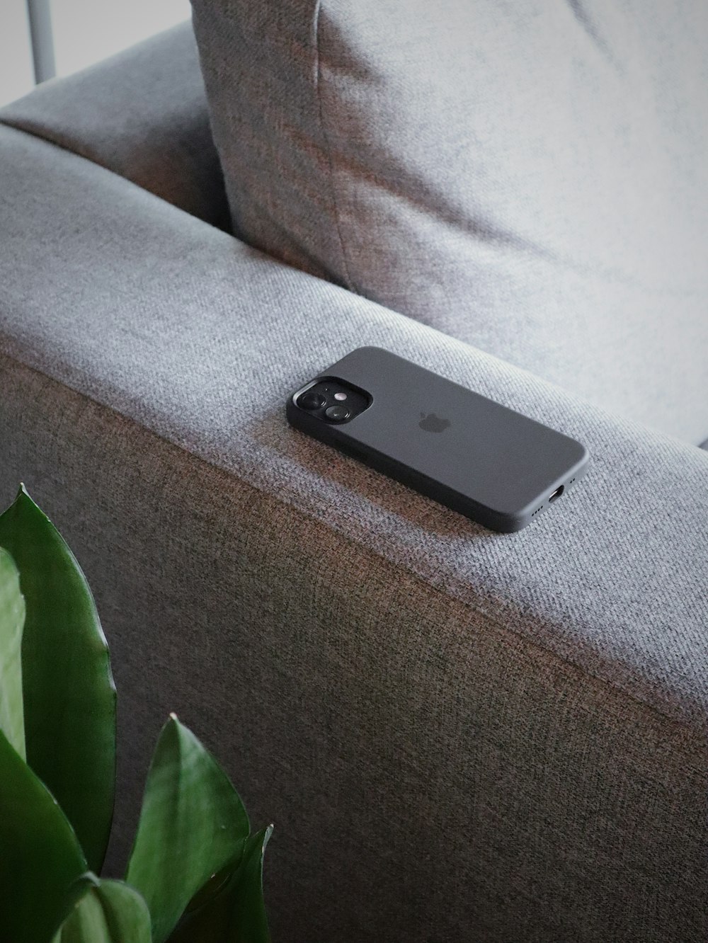灰色のソファに黒いiPhone 5