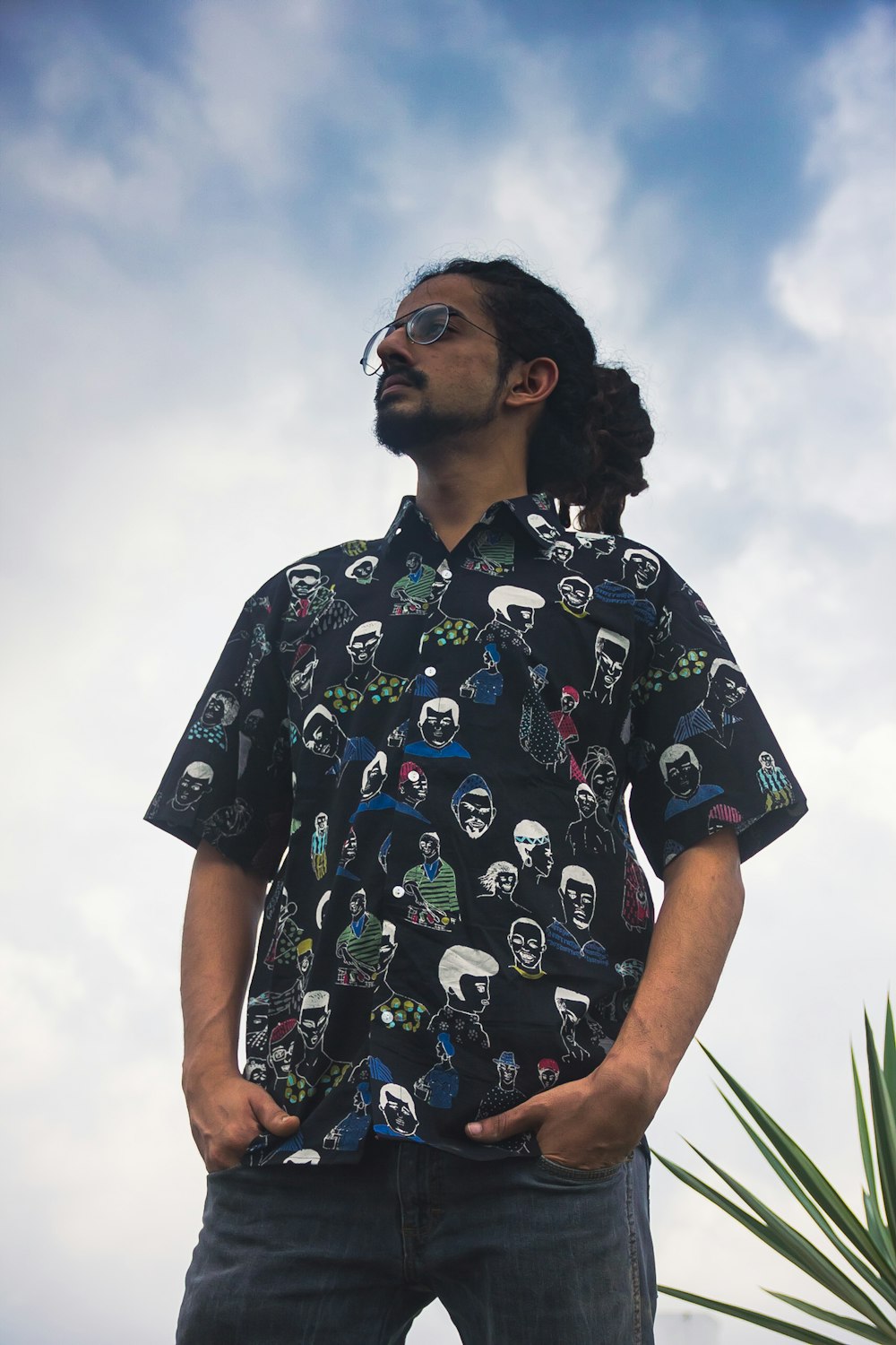 man in black and white crew neck t-shirt standing near green grass during daytime