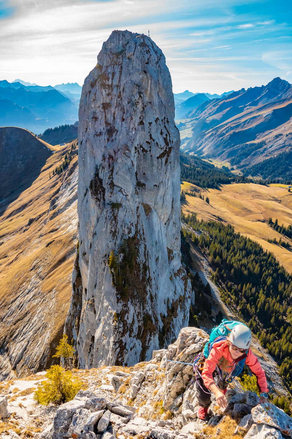 person in blue jacket sitting on rock formation during daytime