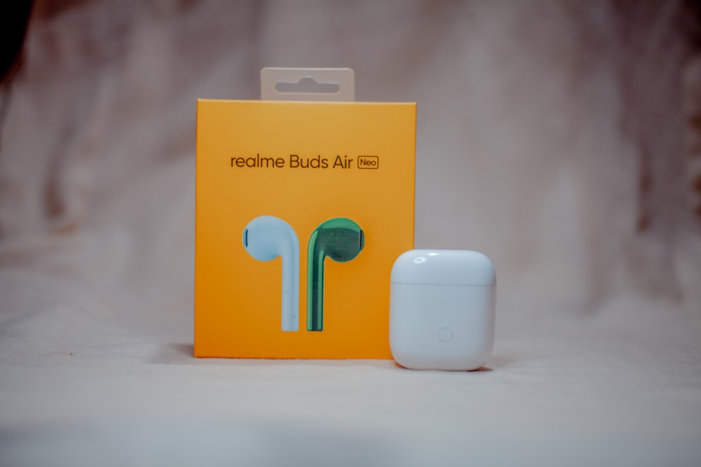 orange and white box with white apple airpods