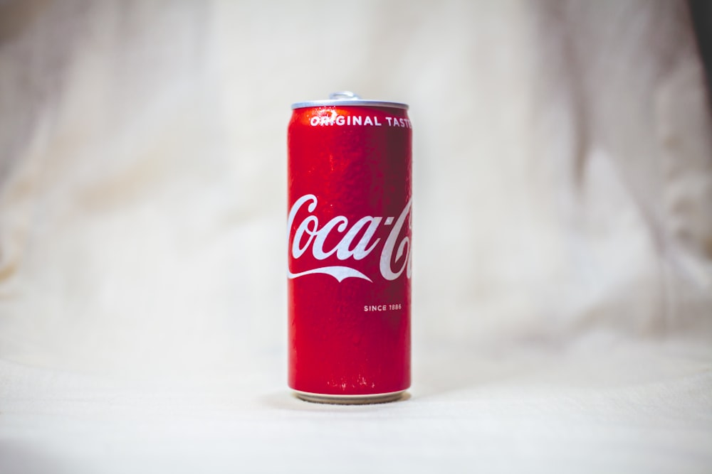 白いテーブルの上のコカ・コーラ缶