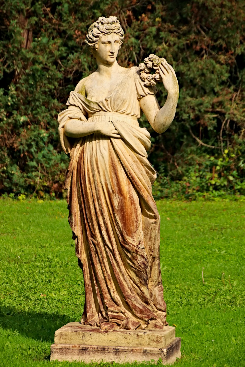 Una estatua de una mujer sosteniendo uvas en sus manos