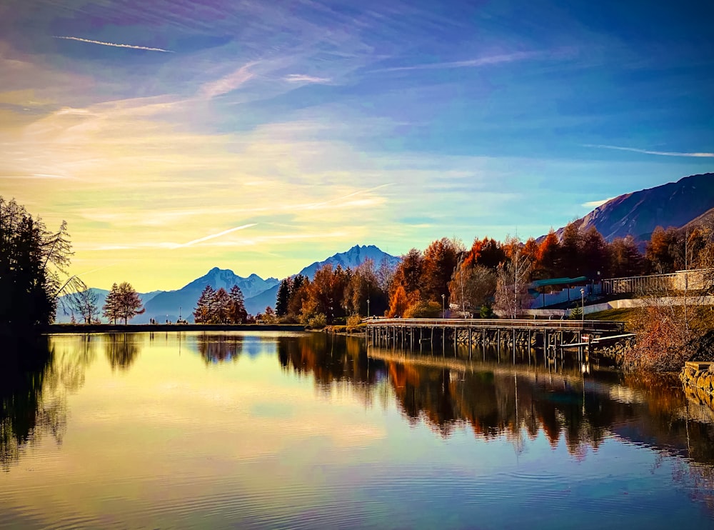 body of water near trees and mountain during daytime