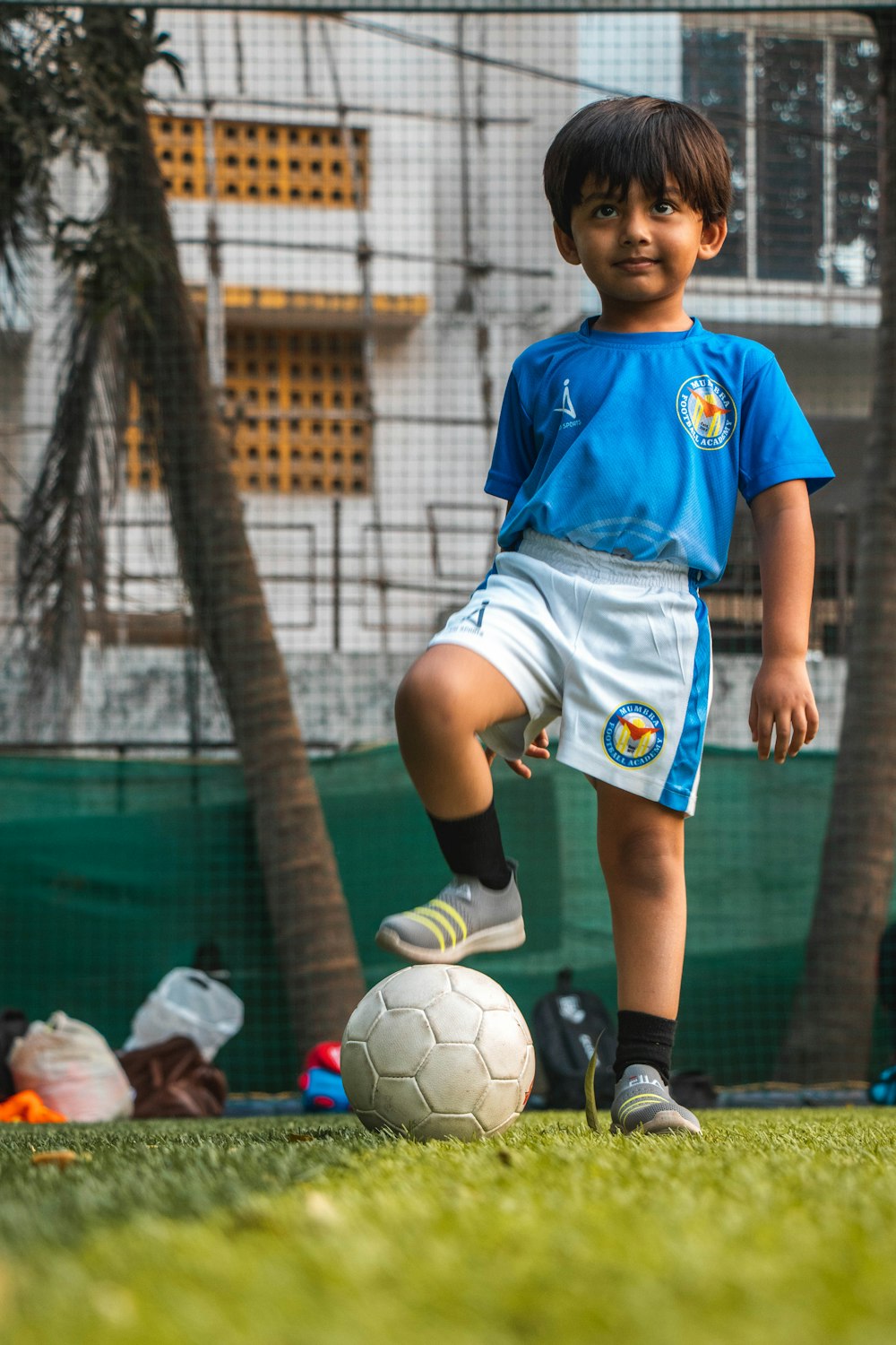 boy in blue soccer jersey shirt and white shorts playing soccer during daytime