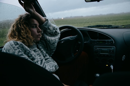 woman in black and white scarf driving car
