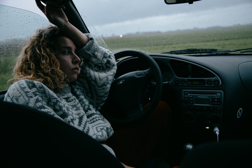 Frau in schwarz-weißem Schal fährt Auto