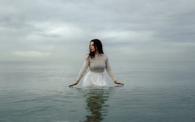 woman in white dress standing on water
