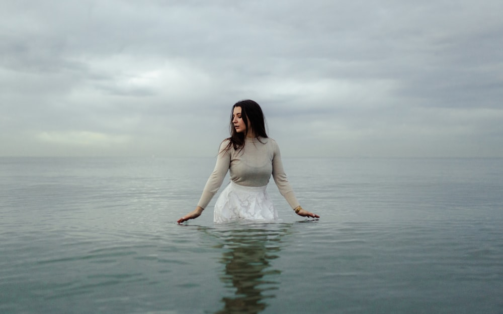 woman in white dress standing on water