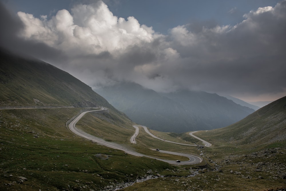 campo de hierba verde bajo nubes blancas durante el día