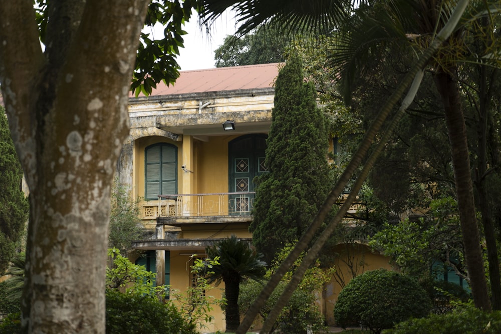 brown and white concrete house near green trees during daytime