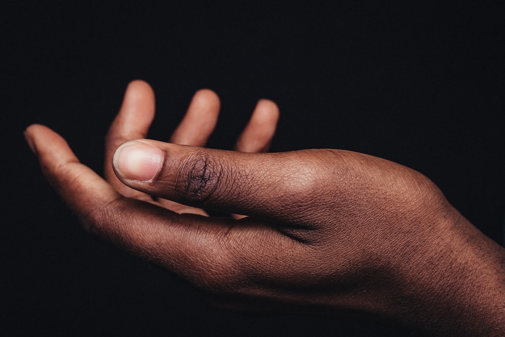 persons hand on black background