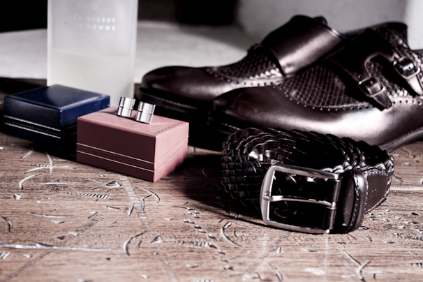 A pair of elegant leather shoes placed next to matching handbags on a wooden surface.