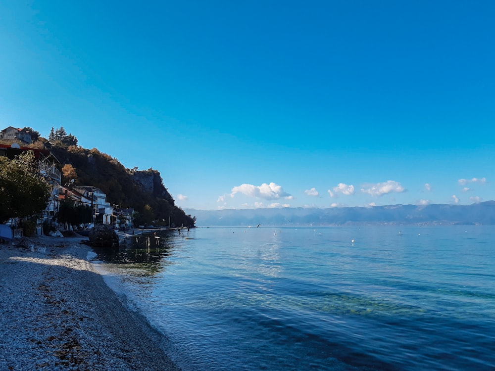 body of water near mountain during daytime