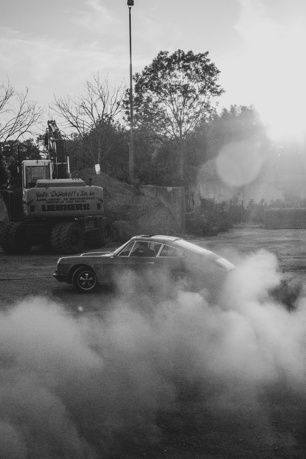 Photo en niveaux de gris d’une voiture près d’arbres