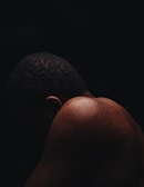 Soft light illuminating a person’s back with faint shadows highlighting muscle tightness.