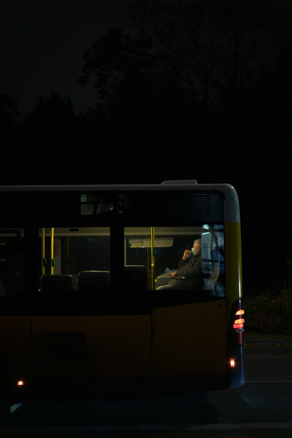 Autobús blanco y azul en la carretera durante la noche