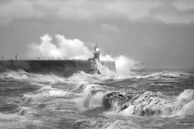 A vibrant painting of a lighthouse standing tall against a stormy sky.