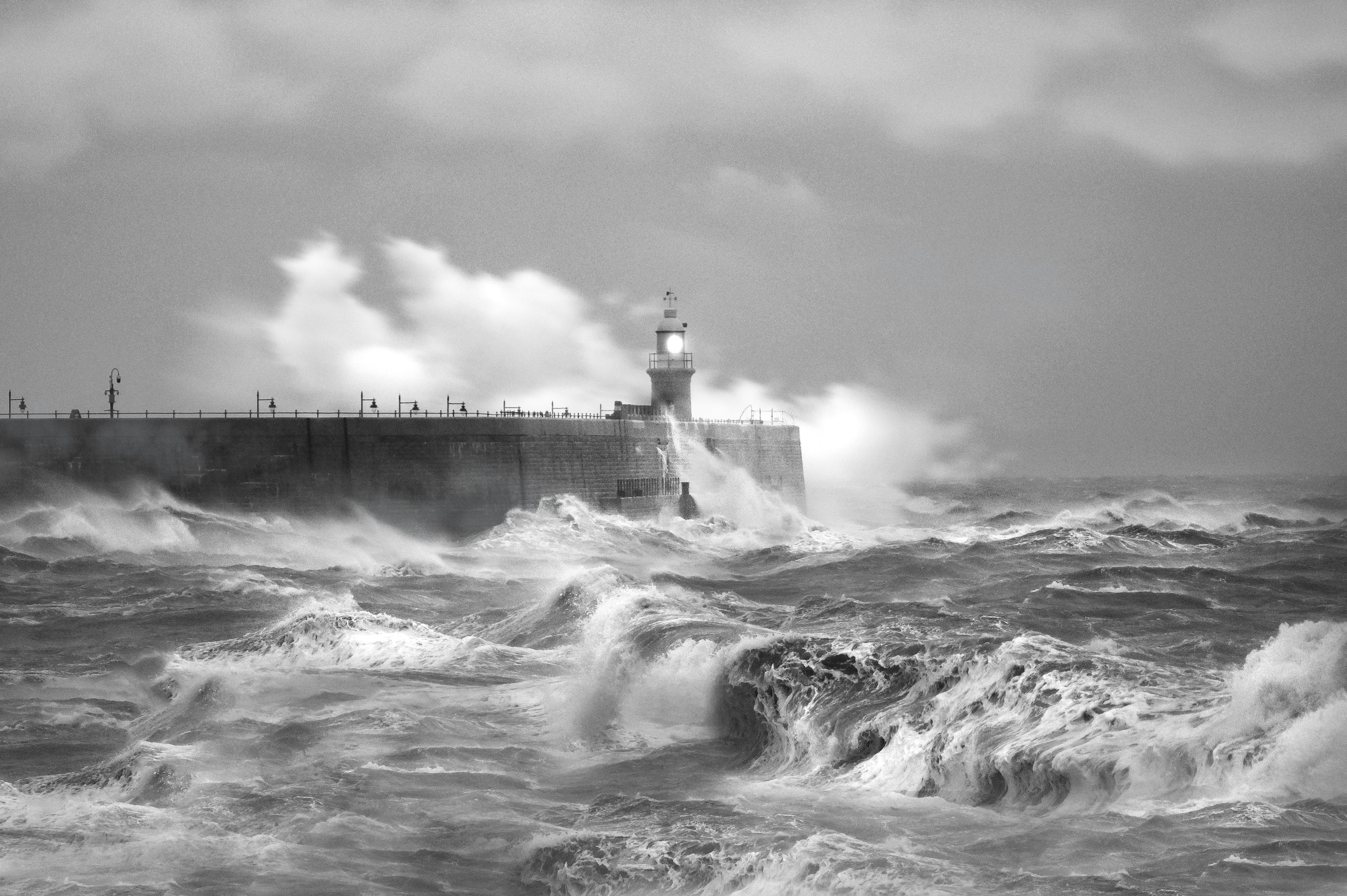 grayscale-photo-of-sea-waves-crashing-on-concrete-wall