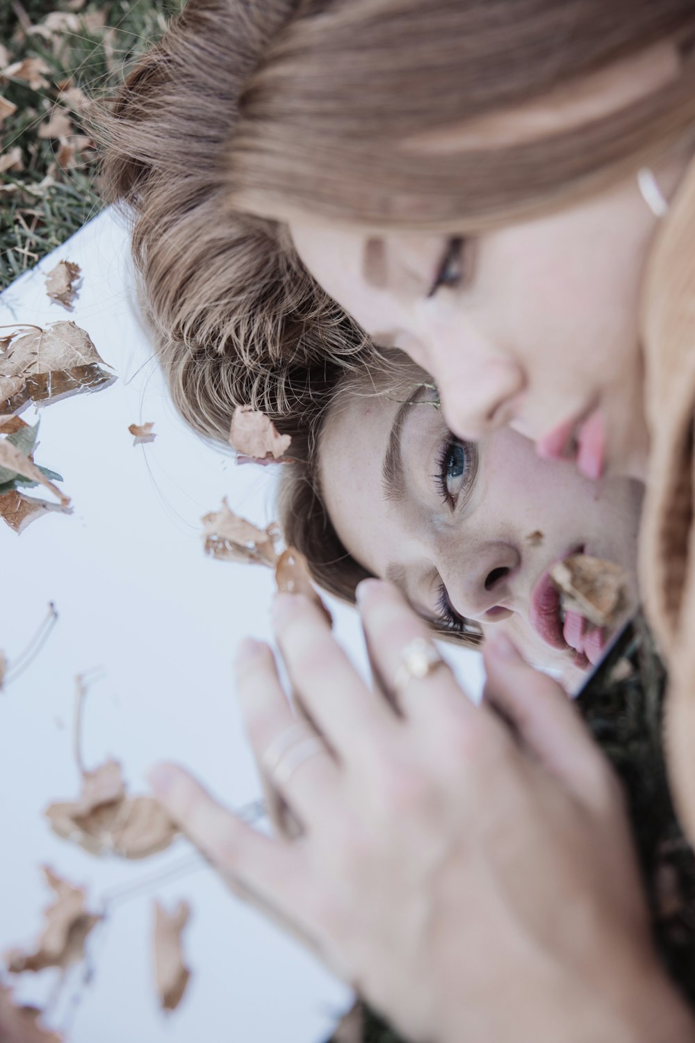 woman with blonde hair holding her face