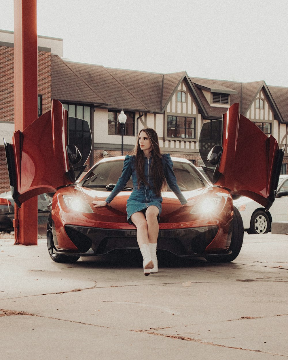 woman in blue denim jacket sitting on red car