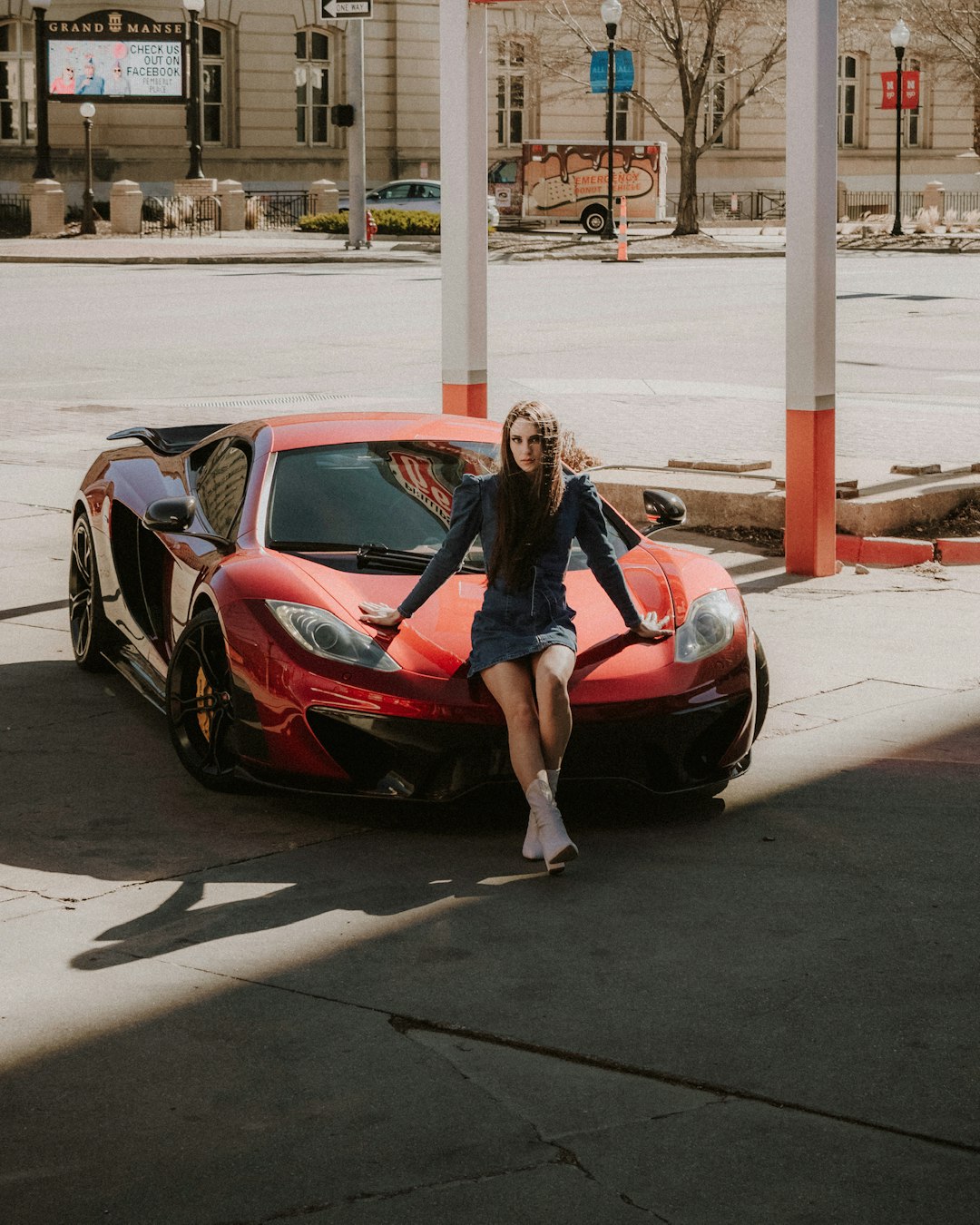 woman in black jacket sitting on red ferrari coupe during daytime