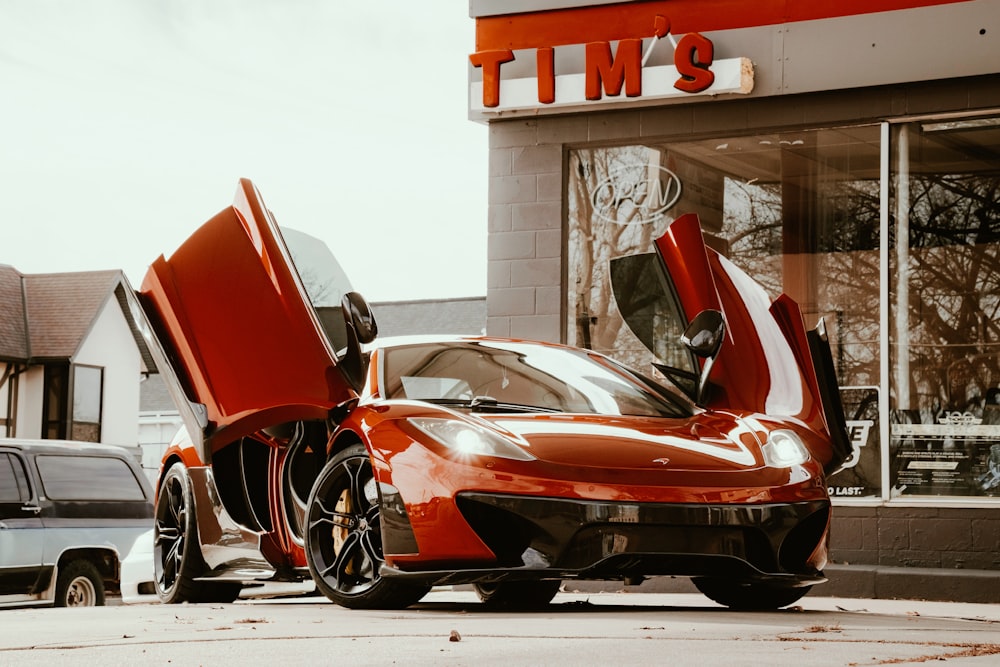 red ferrari 458 italia parked beside white building