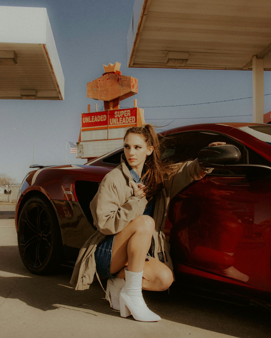 woman in brown coat sitting on red car