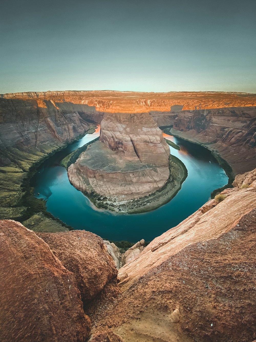 blue lake in the middle of brown rock formation during daytime