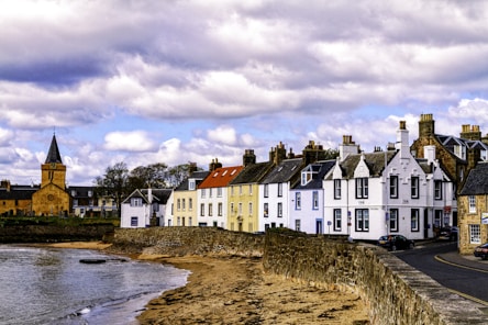 white and red houses beside a small beach under cloudy sky during daytime