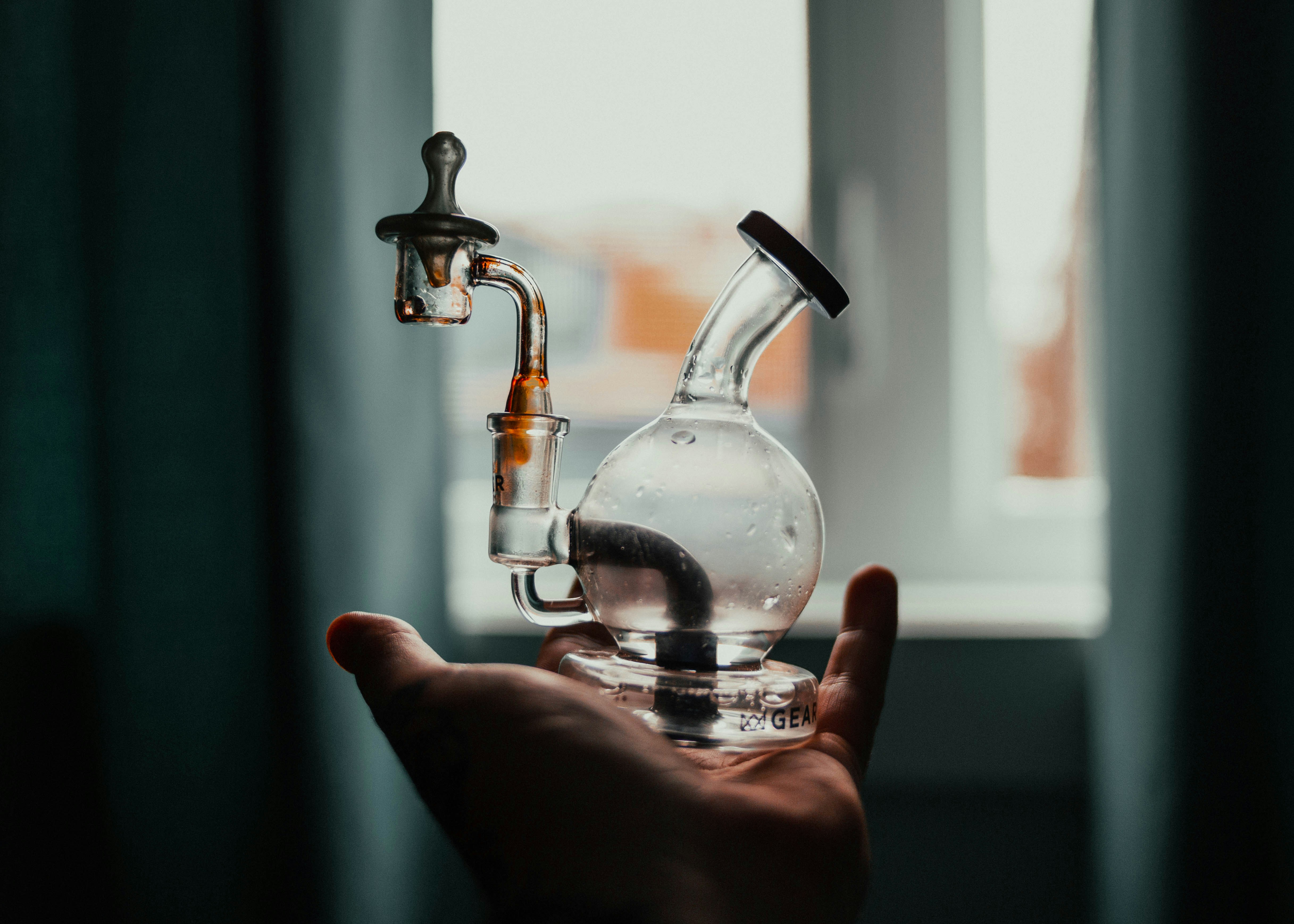 person pouring water from clear glass bottle