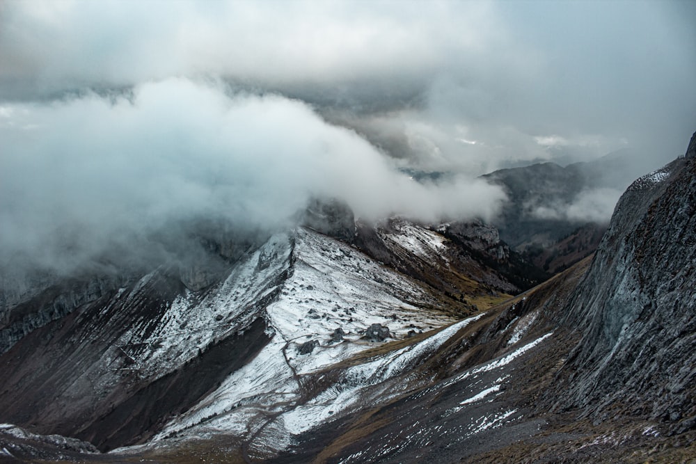 Grauer und weißer Berg unter weißen Wolken tagsüber