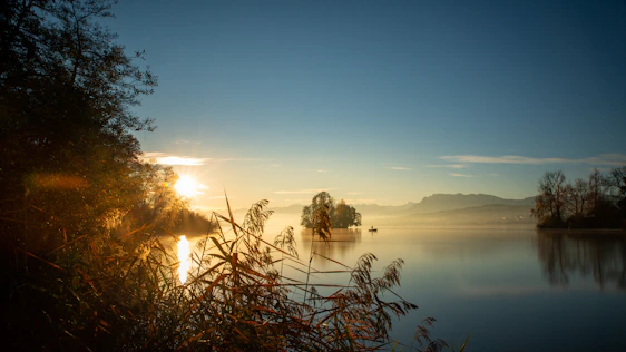 A serene sunrise over a quiet lake symbolizing peace and spiritual renewal.