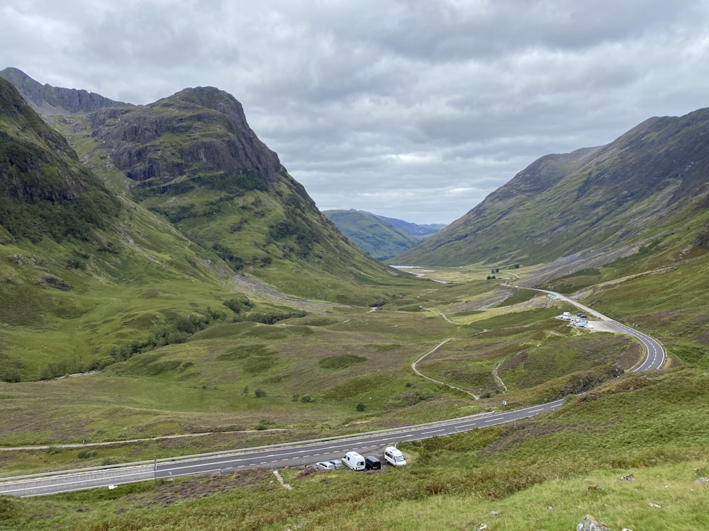 cars on road near mountain during daytime