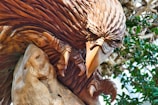 A close-up of a skilled artisan carefully crafting a wooden eagle sculpture.