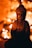 A bronze Buddha statue sits in focus against a blurred background of warm, glowing lights. The lighting casts gentle shadows, creating a serene and contemplative atmosphere.