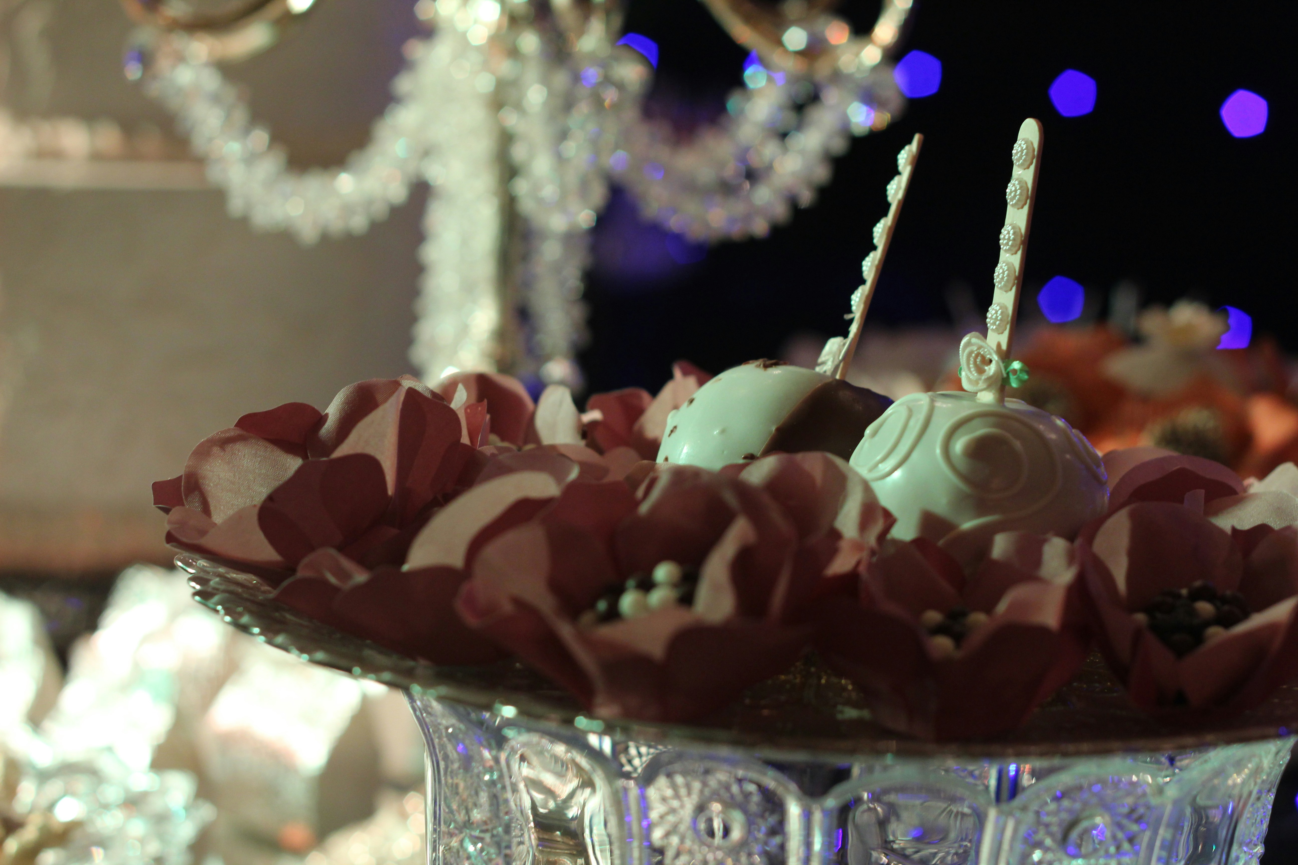 Personalised chocolate favours with custom blush pink printed wrappers on a party table in warm light