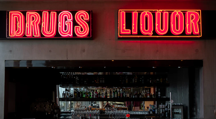 a liquor store with neon signs above the bar